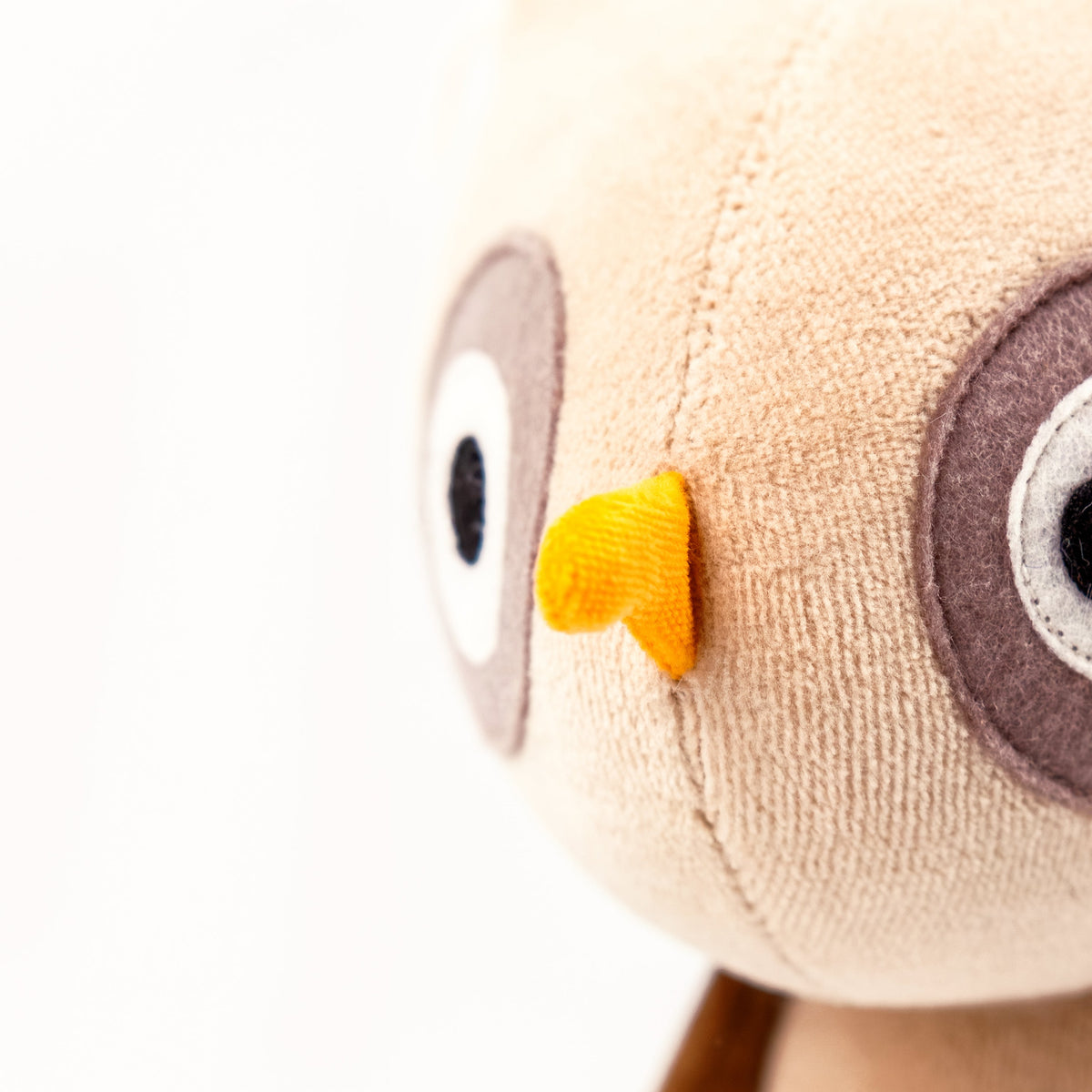 Close-up detail of stuffed owl plush fabric and feathers