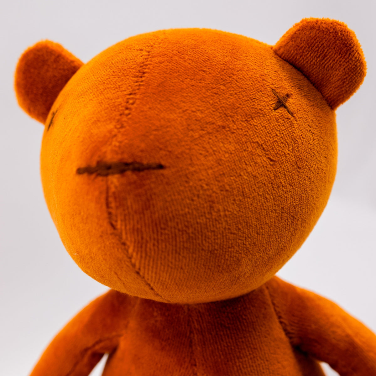 Close-up detail of XXL stuffed teddy bear plush, tobacco brown