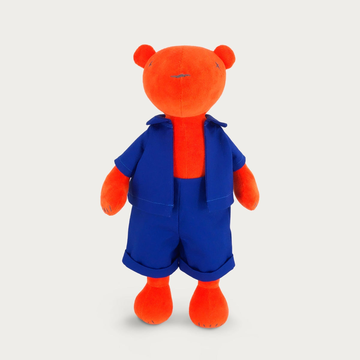 Jermaine the stuffed teddy bear plush, orange, wearing overalls